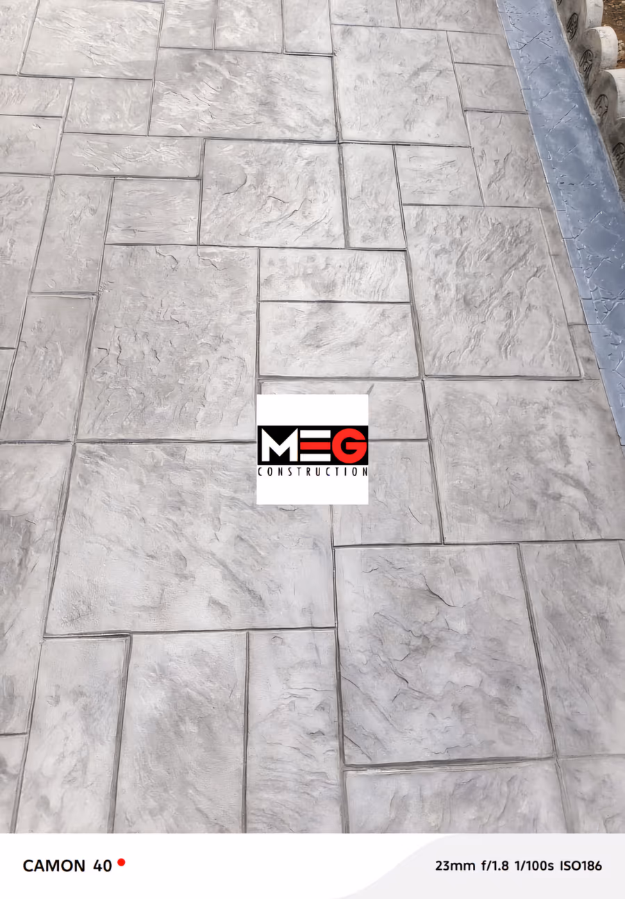 Terrasse en dalle grand format. Béton imprimé, matrice dalle de taille appareillée, bordure ardoise contrastée.