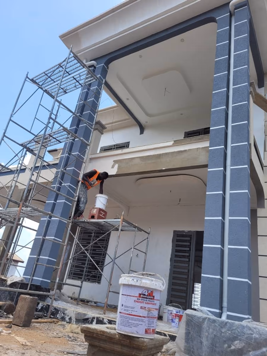 Façade en cours de finition. Application du graffiato sur façade R+1, échafaudage en place. Encadrements et corniches traités avant les grandes surfaces.
