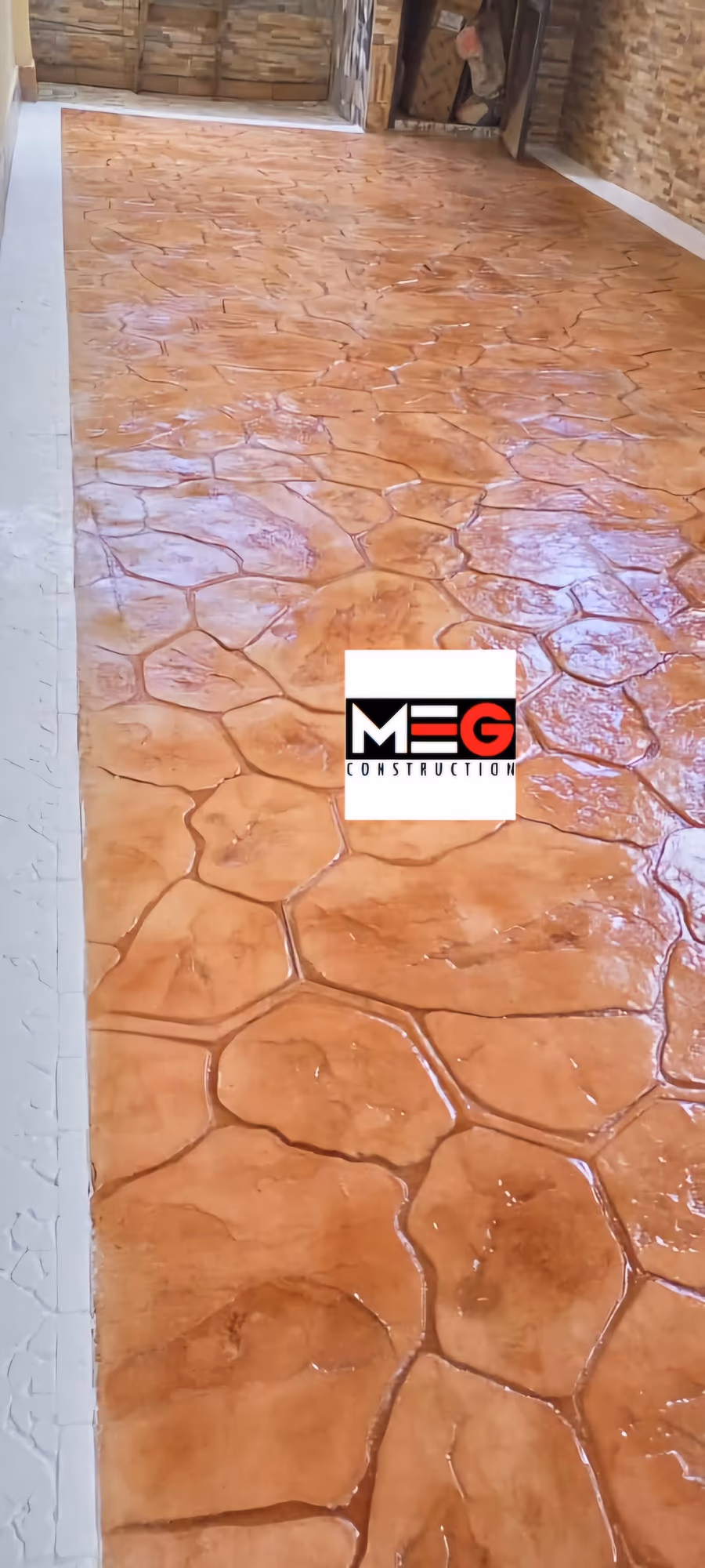 Sol terracotta. Béton imprimé, matrice pierre irrégulière, teinte terre cuite, finition vernie.